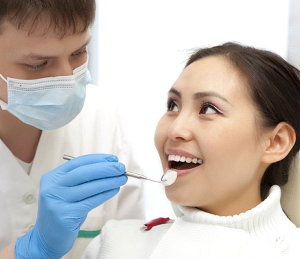 Woman preventing dental emergencies in Flint by visiting her dentist