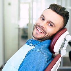 Man smiling in an emergency dental office in Flint