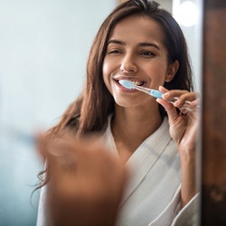Woman brushing her teeth at home
