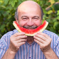 Older man eating a watermelon